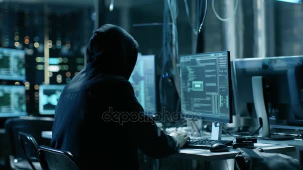 Замасковані Hacktivist організовує масивні даних порушення напад на корпоративні сервери. Вони в підземних таємне місце оточений монітори і кабелів. — стокове відео