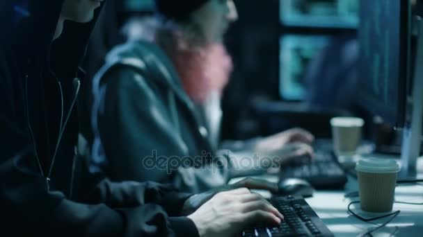 Team of Internationally Wanted Boy and Girl Hackers organise une attaque avancée de logiciels malveillants sur les serveurs d'entreprise. Lieu est sombre et a plusieurs affichages . — Video