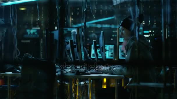 Groep tiener Hackers organiseren aanval op bedrijfsgegevens Servers. Hun hol is donker met Neon verlichting en volledige van operationele Displays. — Stockvideo
