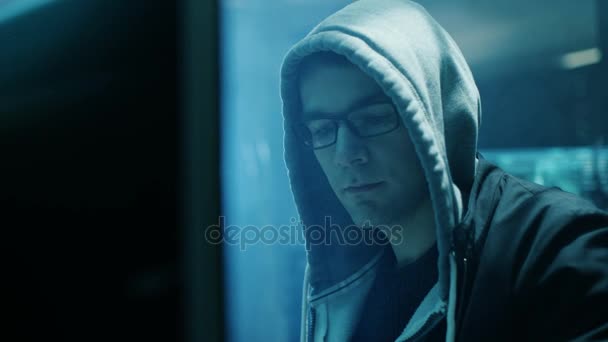 Dangerous Hooded Hacker Breaks into Government Data Servers and Infects Their System with a  Virus. His Hideout Place has Dark Atmosphere, Multiple Displays, Cables Everywhere. — Stock Video