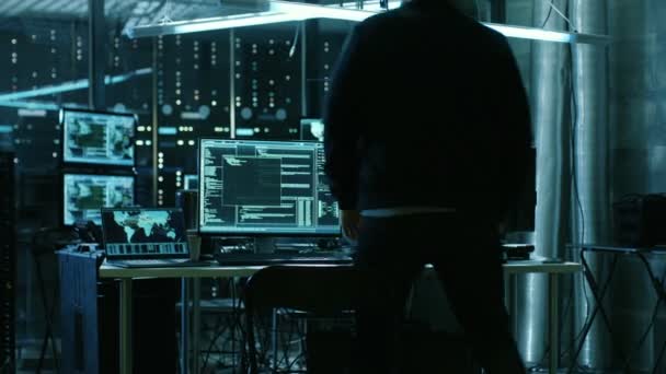 Farlige Hætteklædte Hacker bryder ind i regeringens dataservere og inficerer deres system med en virus. Hans Hideout Place har mørk atmosfære, flere skærme, kabler overalt . – Stock-video