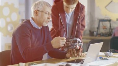 Bilgisayar bilim sınıf öğretmeni inceliyor Robot mühendislik onun öğrencisi tarafından okul projesi için programlı.