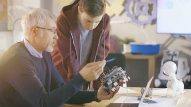 Bilgisayar bilim sınıf öğretmeni inceliyor Robot mühendislik onun öğrencisi tarafından okul projesi için programlı.