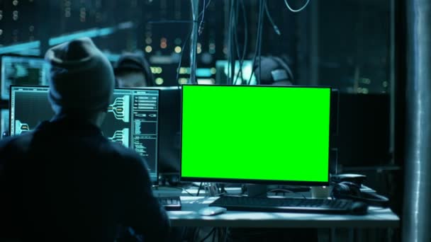 Team international gesuchter Teenager-Hacker mit Green-Screen-Attrappen infizieren Server und Infrastruktur mit Malware. Ihr Versteck ist dunkel, neonbeleuchtet und hat mehrere Displays. — Stockvideo