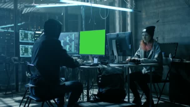 Team international gesuchter Teenager-Hacker mit Green-Screen-Attrappen infizieren Server und Infrastruktur mit Viren. Ihr Versteck ist dunkel, neonbeleuchtet und hat mehrere Displays. — Stockvideo