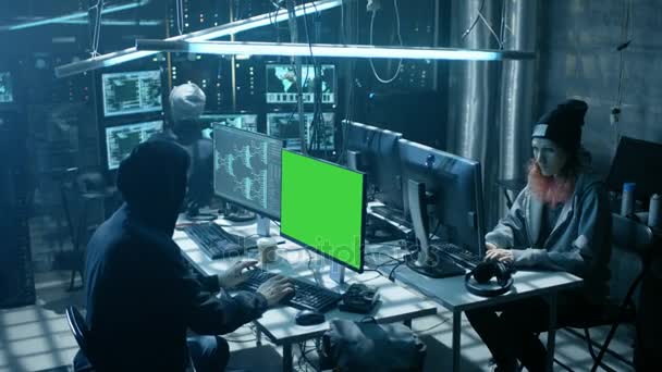 团队的国际想少年黑客与绿色屏幕模拟显示感染服务器和基础架构与病毒。他们的藏身处是黑暗、 霓虹灯点亮和具有多个显示器. — 图库视频影像