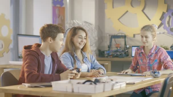 Pojke titta kontroller Mini Drone och två flickor. De är i skolan i Science klass på en Robotics lektion. — Stockvideo