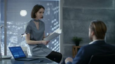 Modern özel Office genç erkek ve dişi başarılı başlangıç Ortaklar önemli belgeler tartışmak. Ofis penceresinin büyük şehir manzaralı vardır.