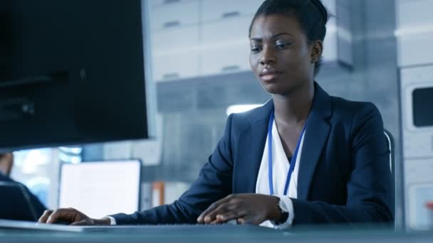 Afro-Amerikaanse vrouwelijke wetenschapper werken op een Computer met haar collega's bij Research Center. Haar collega's zijn Man en vrouwelijke Kaukasische. Laboratorium is Modern. — Stockvideo