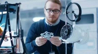 Genç yetenekli erkek mühendis bir Modern laboratuvar prototip 3d printerlere harcama maddeler yardımıyla oluşturur.