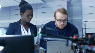 Kadın ve erkek araştırma mühendis bir Modern laboratuvar bir dron prototip üzerinde çalışıyor.