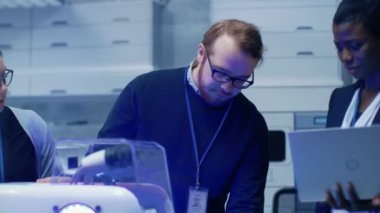 Erkek ve dişi önde gelen bilim adamlarının yenilikçi Robotik teknoloji onlar bina ettik tartışırken çok etnik ekip. Onlar Modern bir laboratuvarda iş / Araştırma Merkezi.