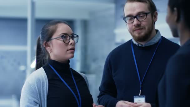 Multi etniska grupp unga och ljusa manliga och kvinnliga forskare diskuterar arbete relaterade frågor i stora moderna laboratorium / Research Center. — Stockvideo