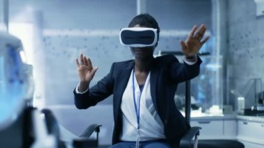 Genç siyah kadın sanal gerçeklik mühendisi / geliştirici Vr kulaklık giyen jest içerik oluşturur. Modern bir laboratuarda yalnız mı / Araştırma Merkezi.