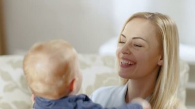 Bir güzel genç anne Holding Her bebek ve o öpüşme kapatın.