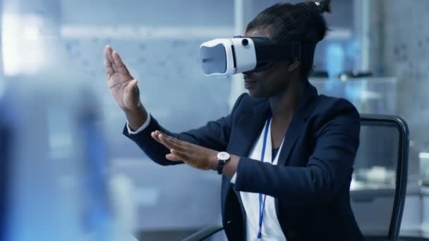 Afro-amerikanska kvinnliga Virtual Reality ingenjör / utvecklare bär Vr Headset skapar innehåll. Hon är ensam i ett modernt laboratorium / Research Center. — Stockvideo