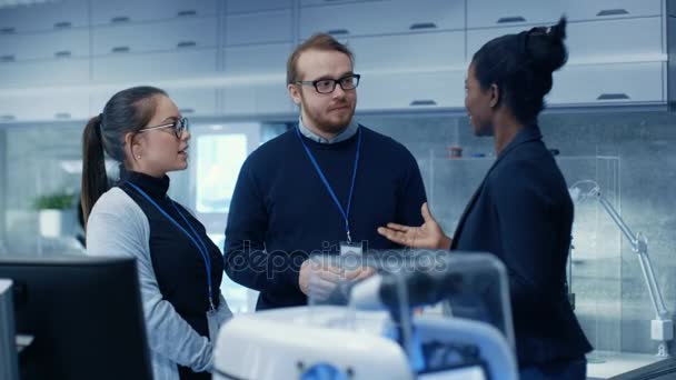 Équipe multiethnique de scientifiques de premier plan masculins et féminins discutant de la technologie robotique innovatrice qu'ils ont bâtie. Ils travaillent dans un laboratoire / centre de recherche moderne . — Video