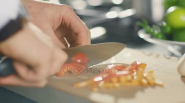 Close-Up ustaca kesme tahtası üzerinde renkli sebze kesme bir şef. Domates ve mantar.