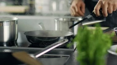 Profesyonel şef aşçılar stil Flambe. O etrafta açık Flames.He çalışmalarında farklı malzemeler ile Modern bir mutfak ile bir tavada yemek hazırlar. 