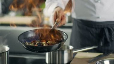 Profesyonel şef aşçılar stil Flambe. O açık alevler ile bir tavada yemek hazırlar. Modern mutfak çevresinde yalan farklı malzemelerle çalışıyor. 