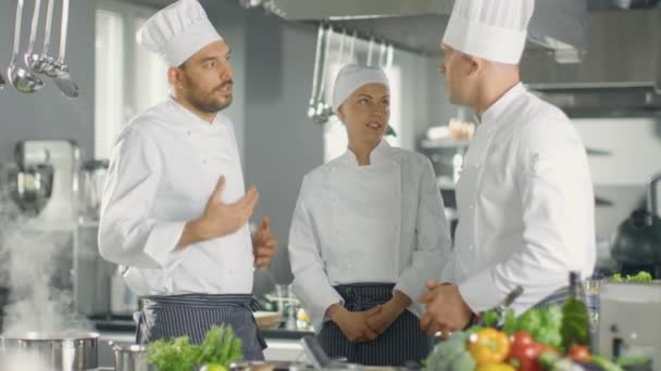 In de moderne keukenteam van koks hebben discussie. Keuken is volledig van voedingsmiddelen en nieuwe voedselingrediënten, vlees, groenten en soep koken. — Stockvideo
