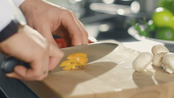 Gros plan d'un chef coupant magistralement des légumes colorés sur une planche à découper . — Video