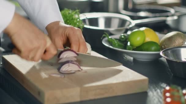 Zbliżenie: szef kuchni mistrzowsko cięcia kolorowe warzywa i cebule na deska do krojenia. — Wideo stockowe
