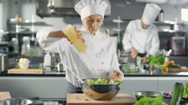 Ünlü restoran kadın aşçı hazırlar salataya, reklamlar petrol. O büyük bir Modern mutfakta çalışıyor.