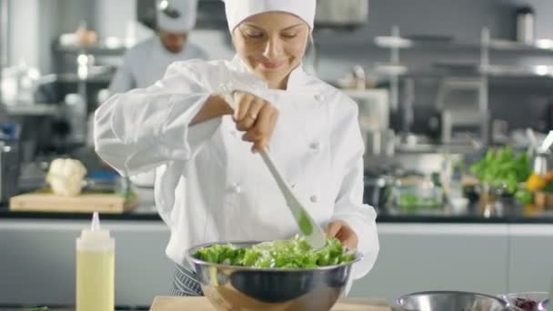 W słynnej restauracji kobieta kucharz przygotowuje sałatki. Pracuje w dużej kuchni nowoczesne. — Wideo stockowe