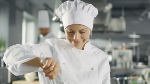 在著名的餐厅女厨师准备食物。她在一个大的现代厨房工作. — 图库视频影像