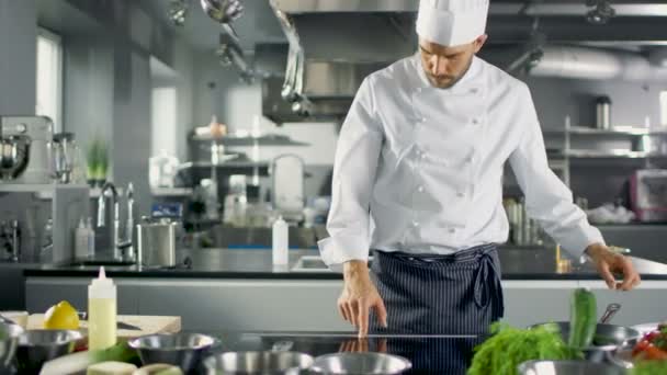 Professionell kock arbetar i berömda restaurang kök. Börjar förbereda hans specialiserade maträtt, vänder på spisen och sätter pannan med olja på det. — Stockvideo