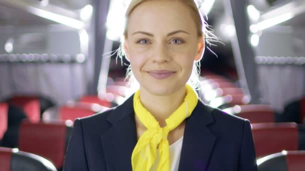 En un avión Hermosa azafata rubia / Asistente de vuelo sonríe con una sonrisa cálida y acogedora. Avión parece nuevo . — Vídeos de Stock