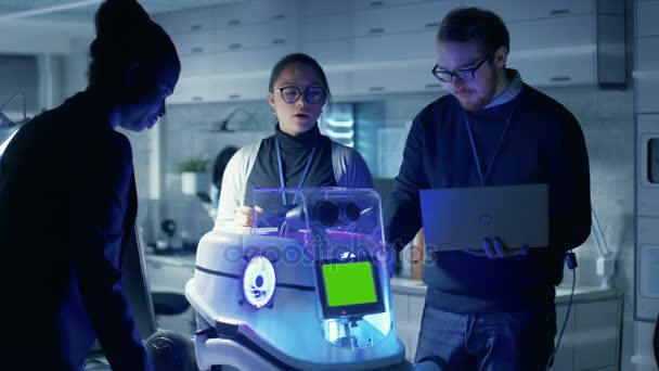 Equipo Internacional de Científicos Líderes Masculinos y Femeninos Trabajan en Tecnología Robótica Innovadora. Robot tiene pantalla verde simulada. Trabajan en un moderno laboratorio / centro de investigación . — Vídeos de Stock