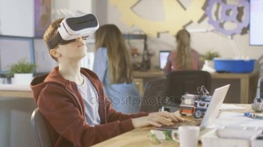 Bir bilgisayar bilim sınıf çocuğu sanal gerçeklik kulaklık giyen bir programlama proje üzerinde çalışıyor.