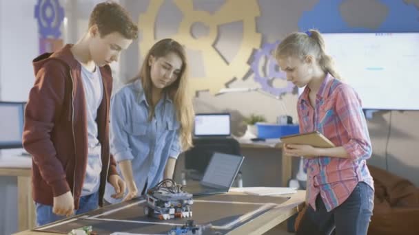 两个女孩和一个男孩程序自我驱动机器人的学校科学类项目. — 图库视频影像