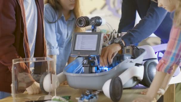 Δάσκαλος και οι μαθητές του εργάζονται για μια προγραμματίσημη ρομπότ με Led φωτισμό για το έργο σχολείο επιστήμη τάξη. — Αρχείο Βίντεο