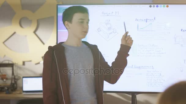 Boy muestra a la clase su presentación en pizarra interactiva para su proyecto para la próxima clase de ciencias escolares . — Vídeos de Stock