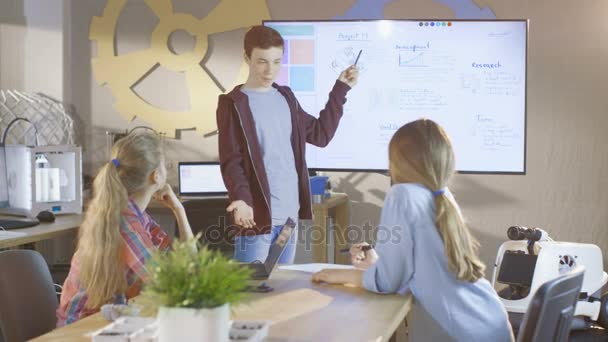 Boy muestra su presentación sobre el proyecto interactivo de pizarra blanca para la próxima clase de ciencias escolares . — Vídeo de stock