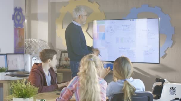 Leraar verklaart les aan zijn Computer wetenschap klasse. Hij maakt gebruik van interactieve Whiteboard. — Stockvideo