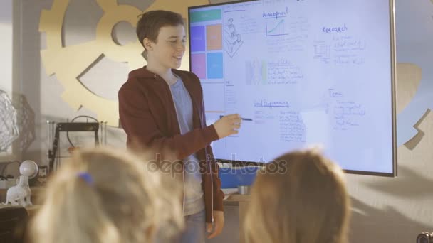 Αγόρι δείχνει στην τάξη την παρουσίασή του στο διαδραστικό πίνακα για το έργο του για την προσεχή σχολική τάξη επιστήμη. — Αρχείο Βίντεο