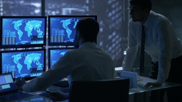 Tarde da noite no Office Building Security Service Men Discutem enquanto Atentamente Observam Monitores com Localização Informações Sensíveis Mostradas neles . — Vídeo de Stock