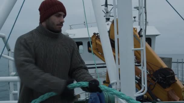 Un marin sérieux tire la corde pendant qu'il voyage à bord d'un navire — Video