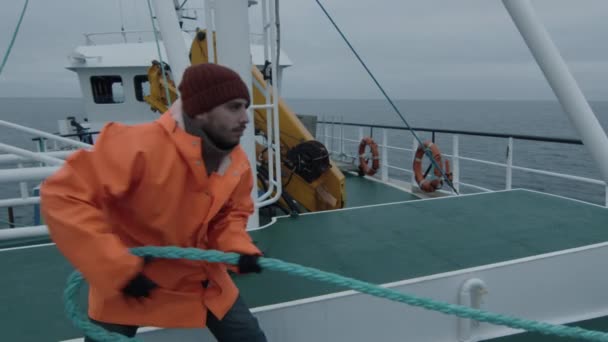 Серйозні моряк тягне товсті мотузку під час подорожі на кораблі — стокове відео