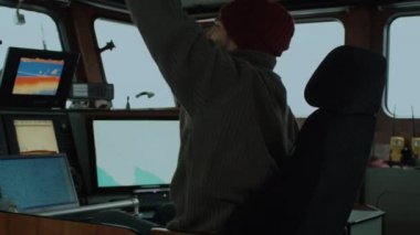 Ticari balıkçılık gemi çevrili monitörler ve ekranlar çalışma onun kabinde deniz haritalarıyla kaptanı.