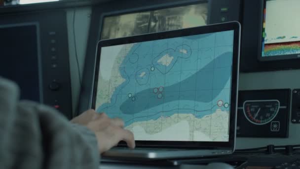 Kapten av kommersiellt fiske fartyg omgiven av bildskärmar och skärmar arbetar med havet kartlägger i sin hytt. — Stockvideo