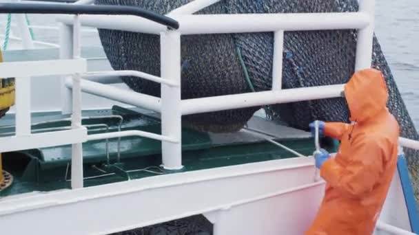 Un pêcheur ouvre un filet de chalut avec du poisson d'augth à bord d'un navire de pêche commerciale — Video