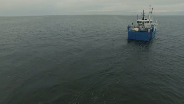 Prise de vue aérienne d'un bateau de pêche commerciale qui tire un filet de chalut 