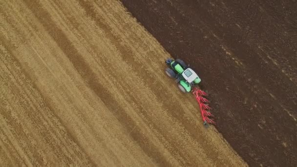 BirdsEye utsikt över en traktor plöjer fält. Tydlig linje av slutfört arbete är synlig. — Stockvideo