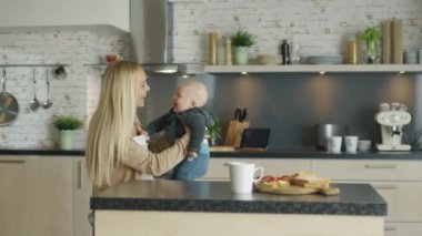 Genç anne Hemşirelik Her gülüyor mutfak ayakta iken çocuk.