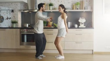  Mutlu genç çift dansları mutfakta kadar biten bir kucaklama.